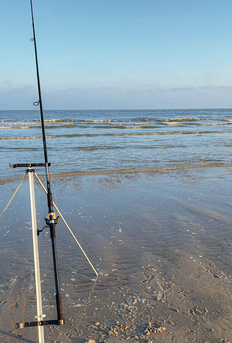 Een vishengel op het strand van Vlieland, gericht op de Noordzee.